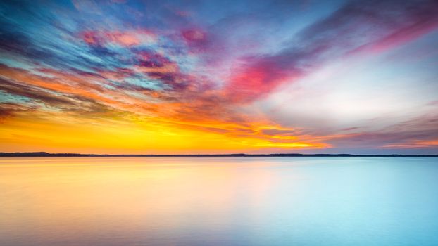 A stunning sunset scene with vibrant skies reflecting on serene ocean waters, perfect for nature enthusiasts.
