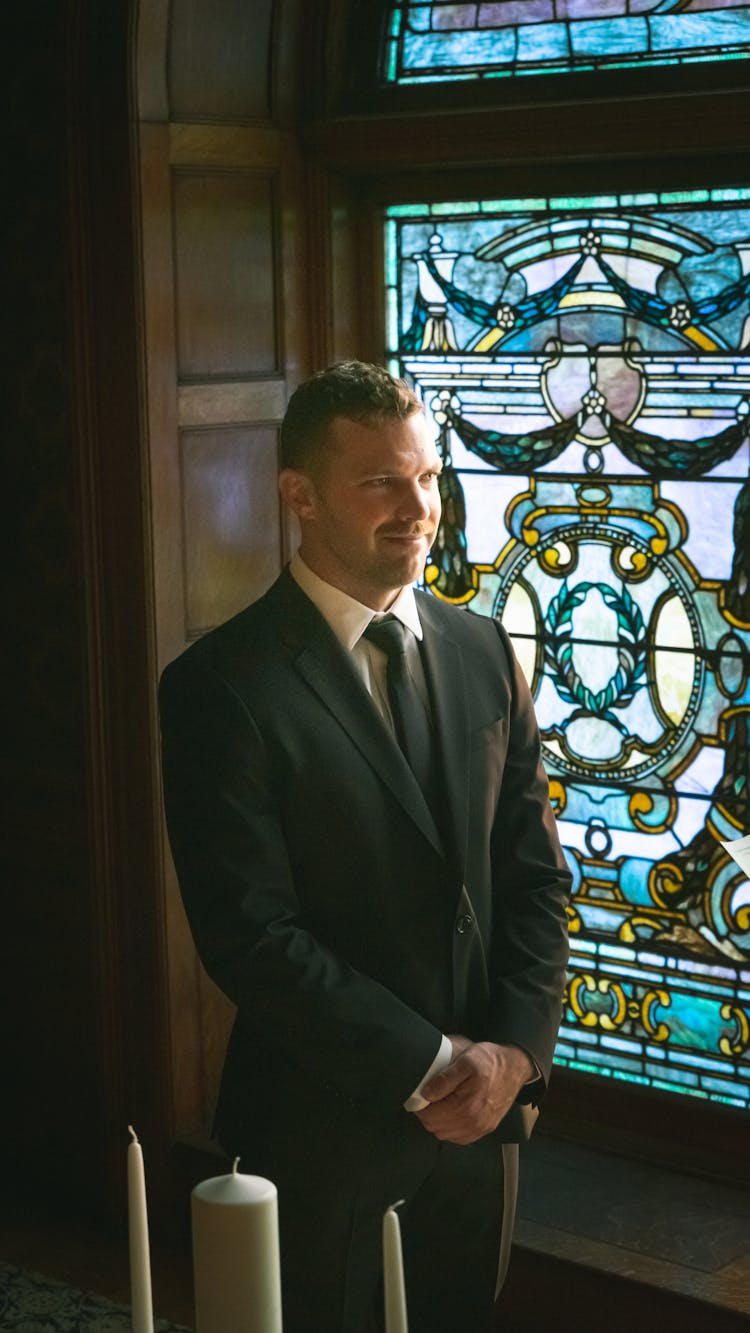 Happy Groom In Classic Suit In Church With Candles