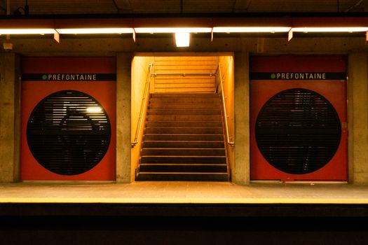 Interior view of Montréal's Préfontaine subway station with stairs and platform.