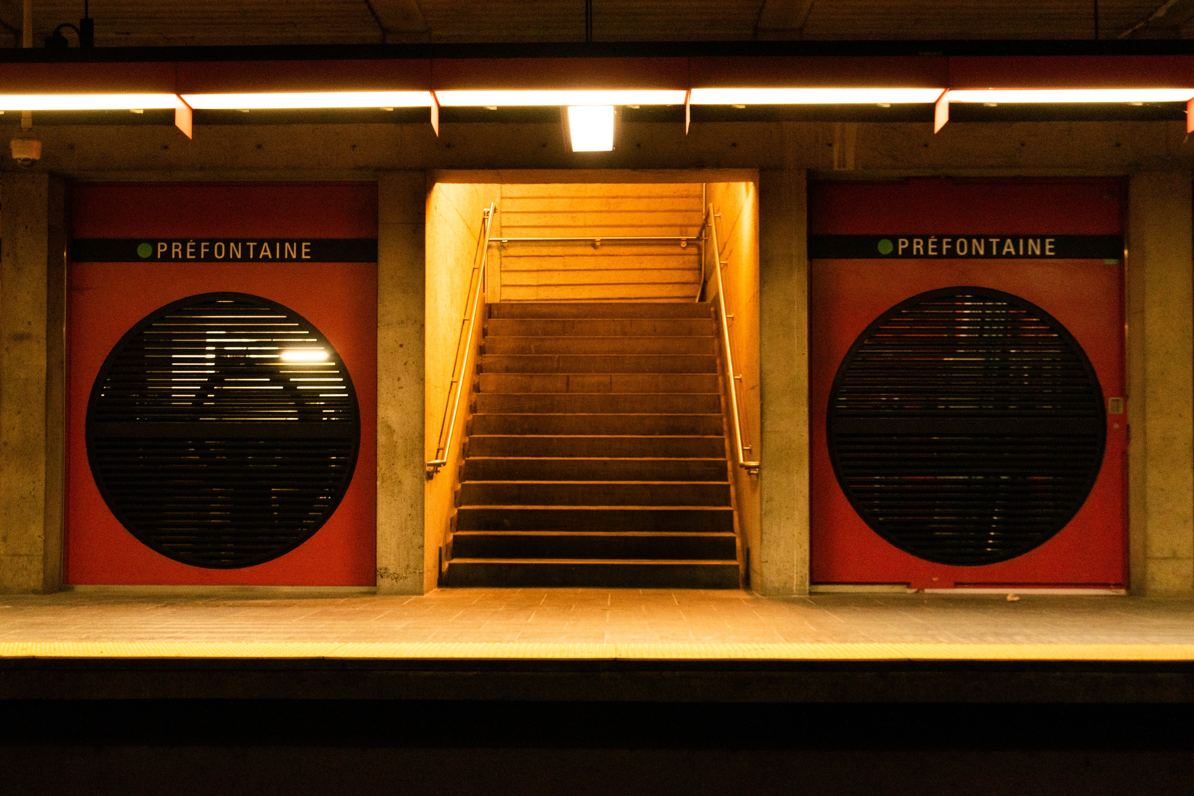 Interior view of Montréal's Préfontaine subway station with stairs and platform.
