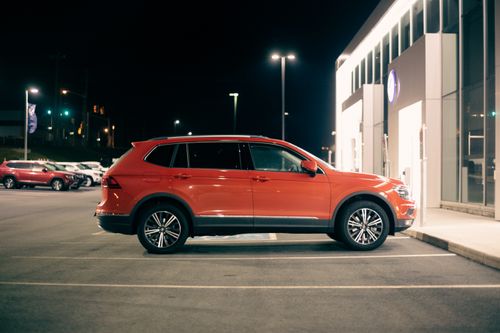 Free Luxury red off road car with glossy body parked near store entrance at night Stock Photo