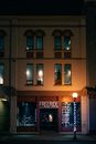 Sidewalk with glowing streetlamp and showcase of store selling bikes and equipment for active sport