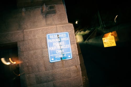 Signboard restricting parking for cars on reserved area for police vehicles at night