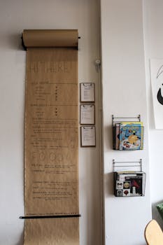 Vertical café menu on brown paper with nearby magazines on a wall in a cozy setting.