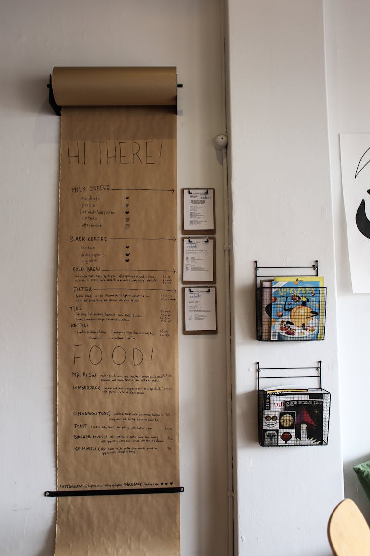 Menu On Grey Paper On Cafe Wall And Leaflets In Baskets