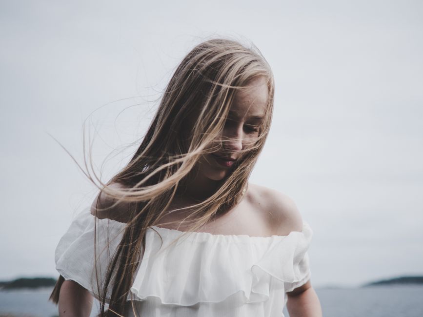 A serene portrait of a woman outdoors in soft natural light, evoking a peaceful mood.
