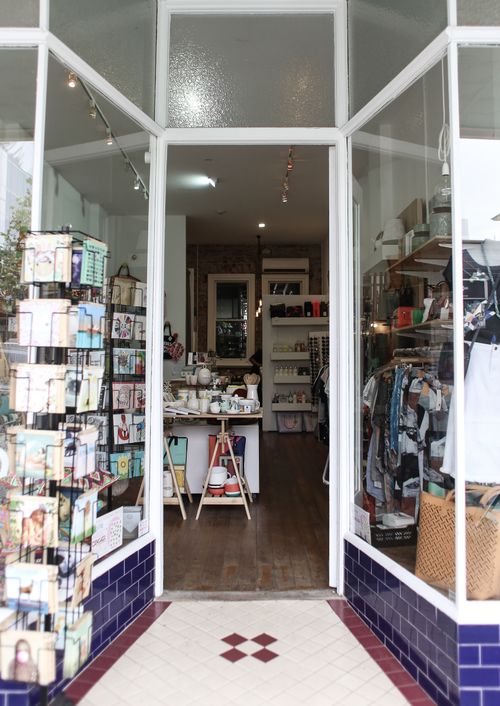 Free Elegant boutique entrance showcasing diverse merchandise for a unique shopping experience. Stock Photo