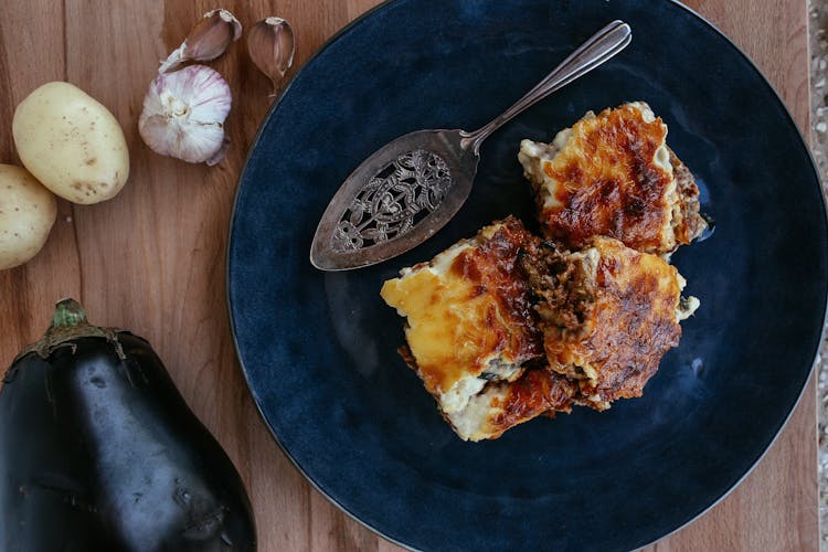 Stainless Steel Spoon On Blue Ceramic Plate With Vegetarian Eggplant Lasagna