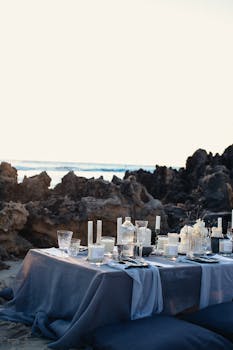 Sophisticated beach dining with blue tablecloth and candles, perfect for luxury events.