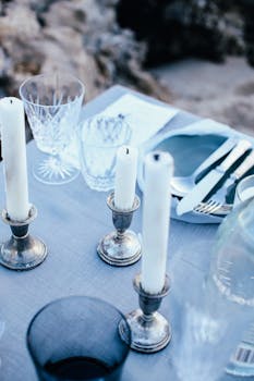A sophisticated outdoor table setting featuring candles and crystal glassware. Perfect for elegant receptions.