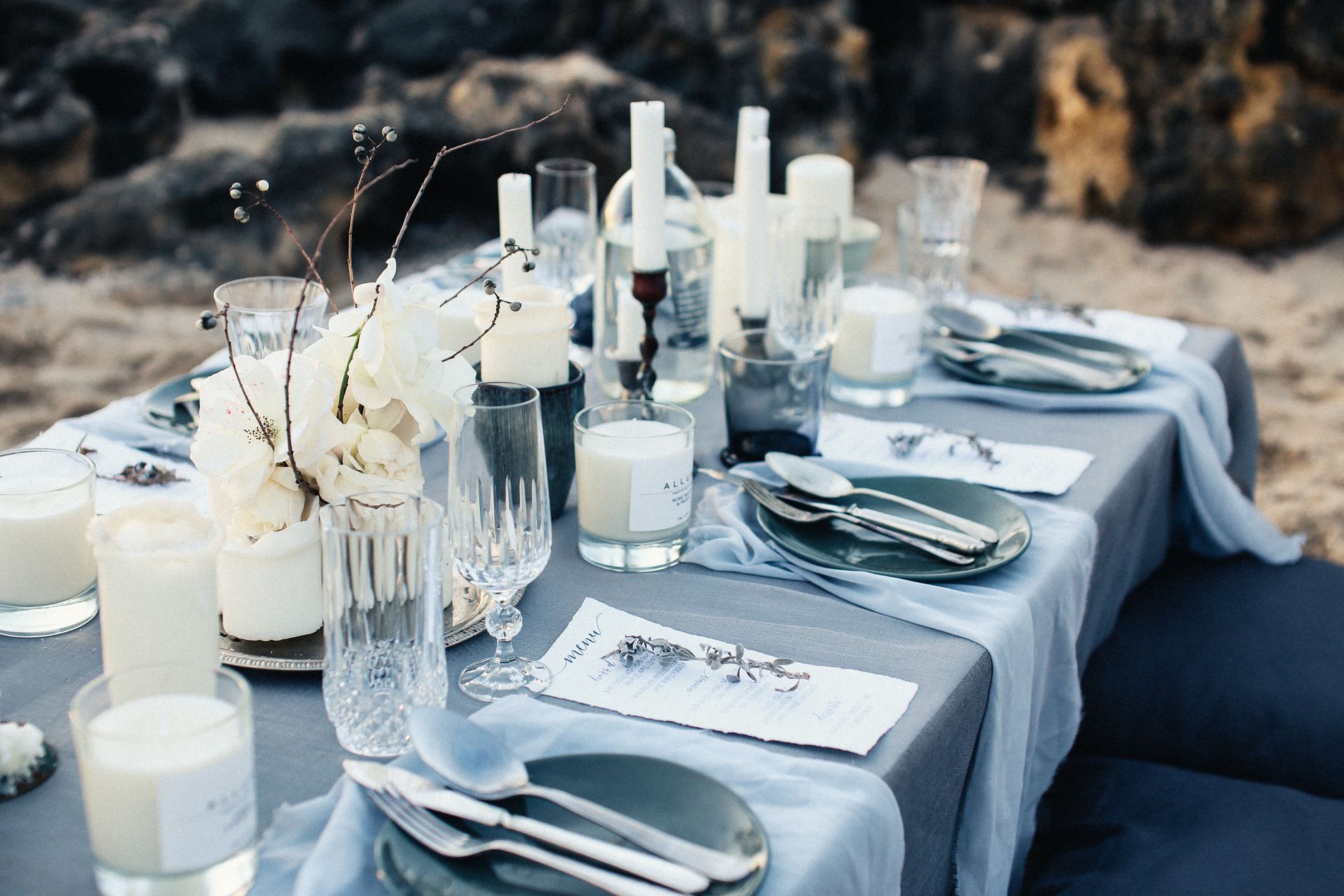 Beautifully set outdoor dining table with elegant decor and candles.