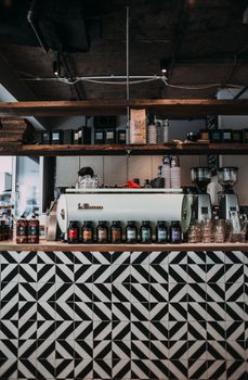 Stylish café interior featuring a geometric tiled counter and professional coffee equipment setup.