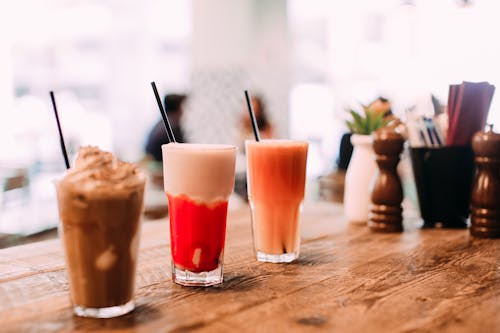 Glass of Chocolate Smoothie and Cocktail Drinks on Wooden Table