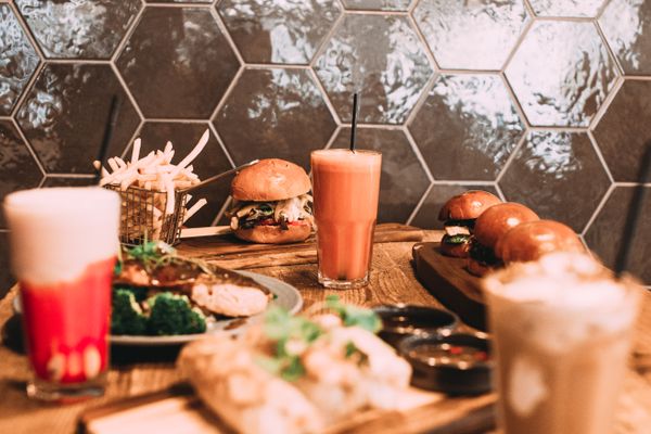 Spread of burgers, fries and drinks on a table, photo by Rachel Claire on Pexels