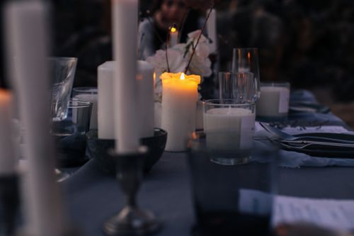 Free An intimate candlelit dinner setup with elegant glassware and cutlery under a nighttime ambiance. Stock Photo