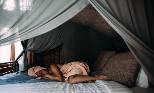 Free Woman Lying on Bed wrapped around a Towel  Stock Photo