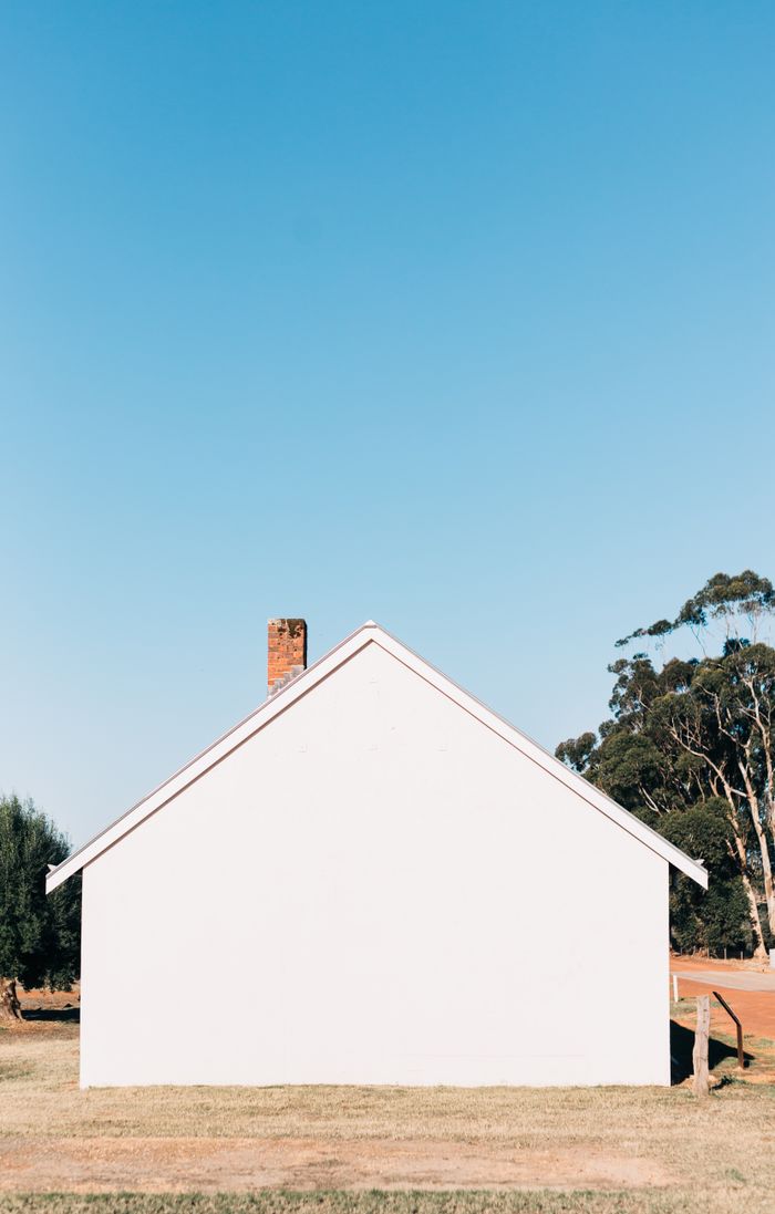 White gabled building standing alone under open sky — photo by Rachel Claire on Pexels