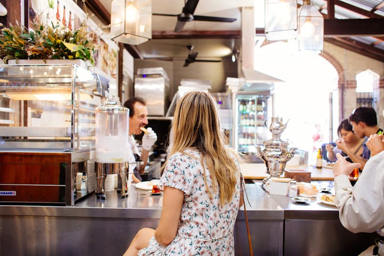 Woman Sitting In Front Of A Restaurant Counter