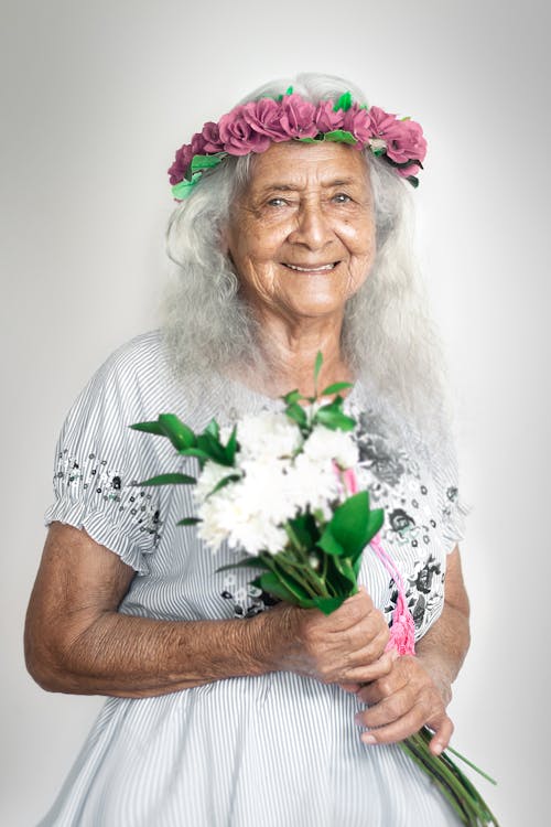 Elderly Woman Holding a Bunch of Flowers
