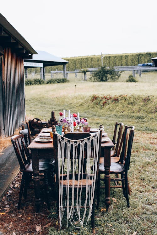 Dinner Table Setting on a Yard Next to a Wooden House on a Countryside 
