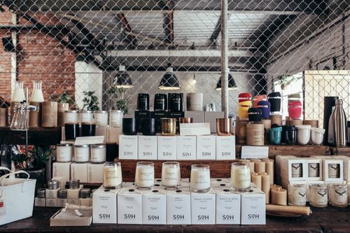 Free A curated display of handmade candles and home goods on a rustic counter, perfect for cozy interiors. Stock Photo