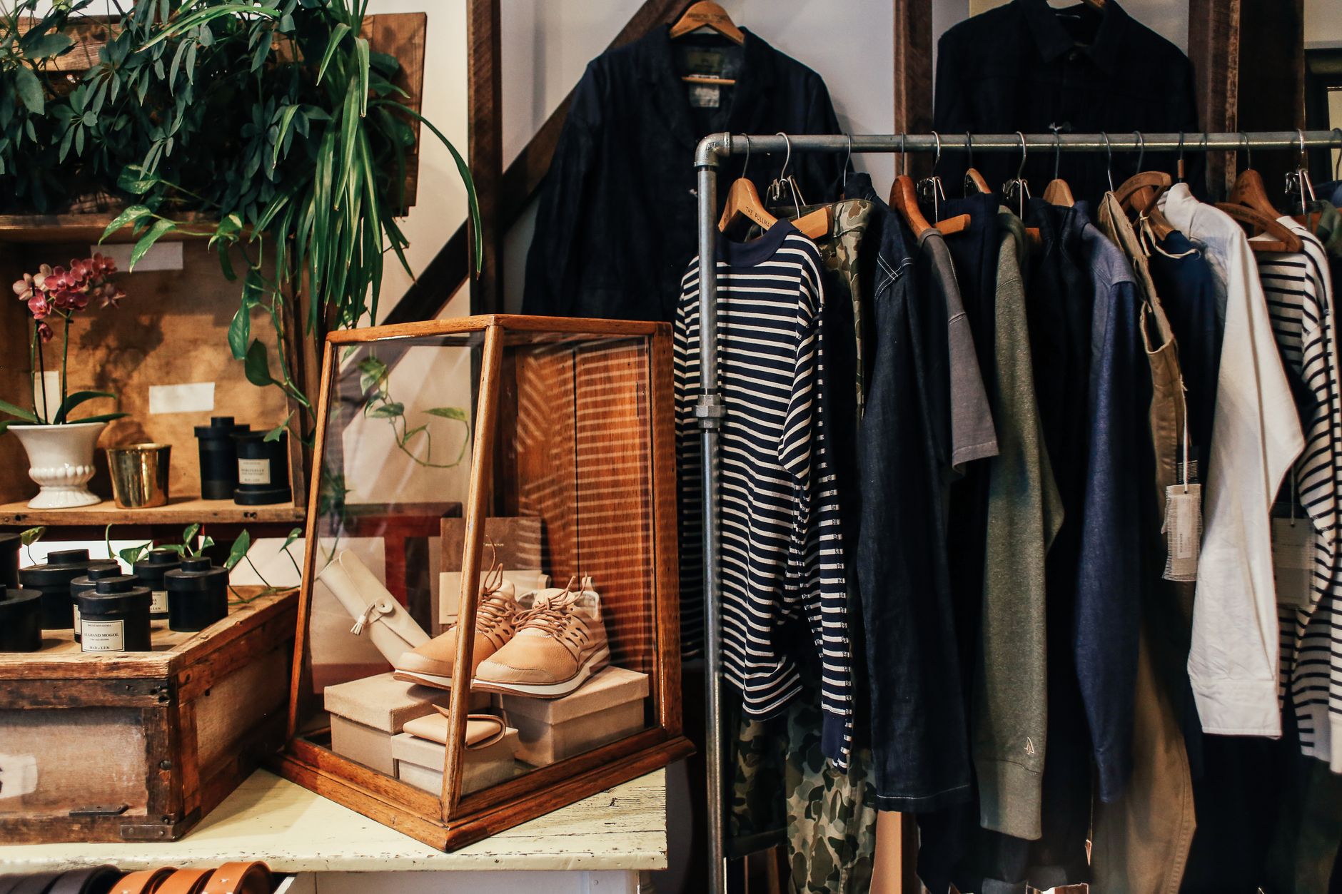 A stylish boutique clothing rack featuring diverse apparel and accessories in a cozy, natural setting.