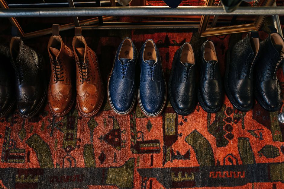 A collection of classic leather shoes displayed on a colorful vintage carpet, showcasing elegant fashion.