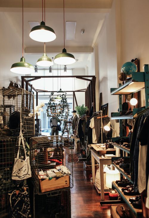 Free Stylish vintage boutique showcasing fashion items and decor with warm lighting and unique displays. Stock Photo