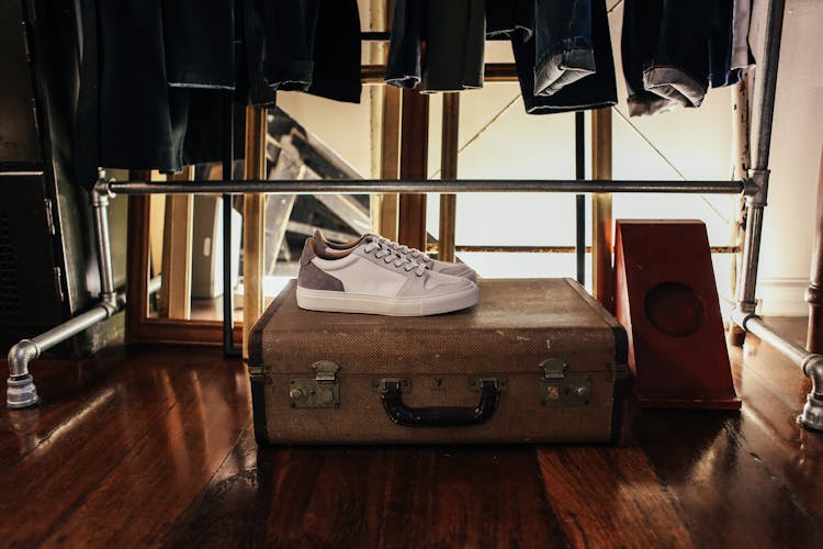 White Sneakers On Brown Suitcase