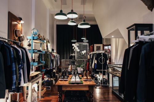 Free Chic clothing boutique with stylish clothing racks and accessories on display. Stock Photo