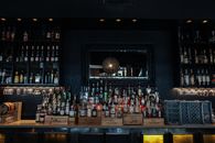 Clear Glass Bottles on Bar Counter and Shelves
