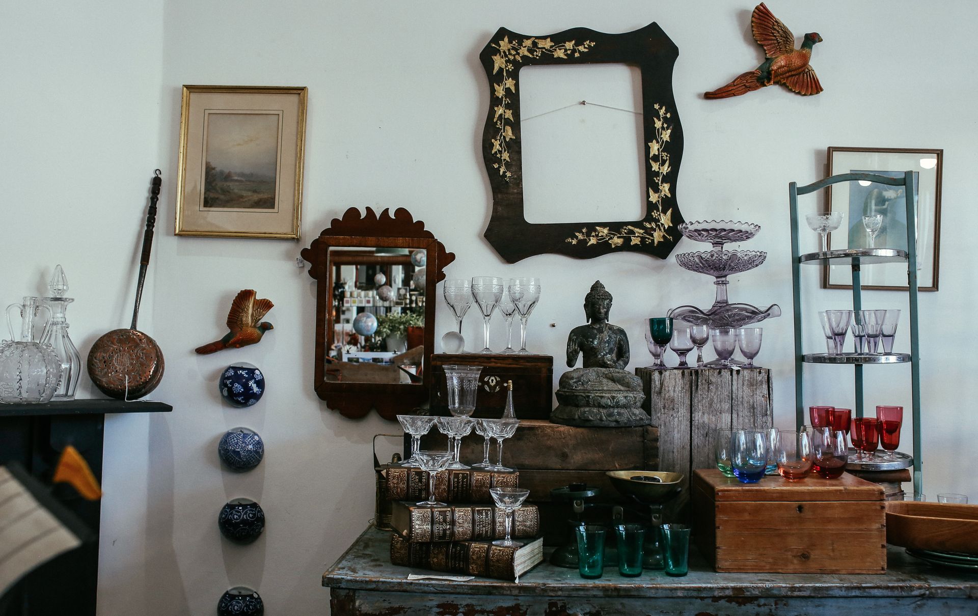 A cozy rustic home interior featuring vintage decorations and a mix of glassware and art pieces.