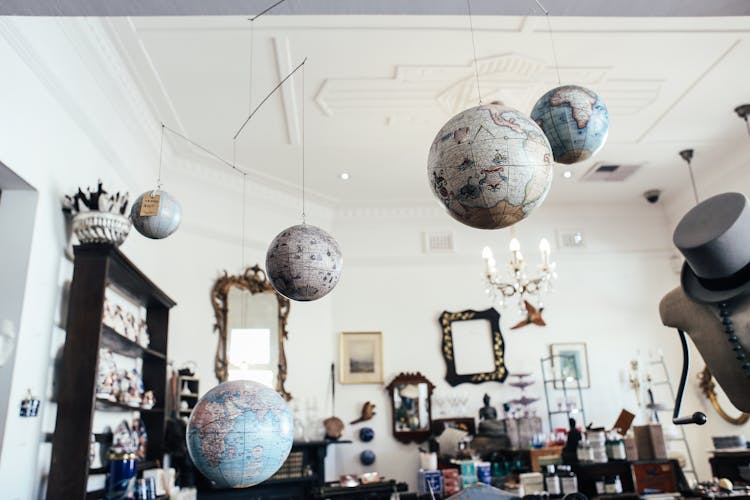 Globes Hanging From Ceiling In A Room With Antiques