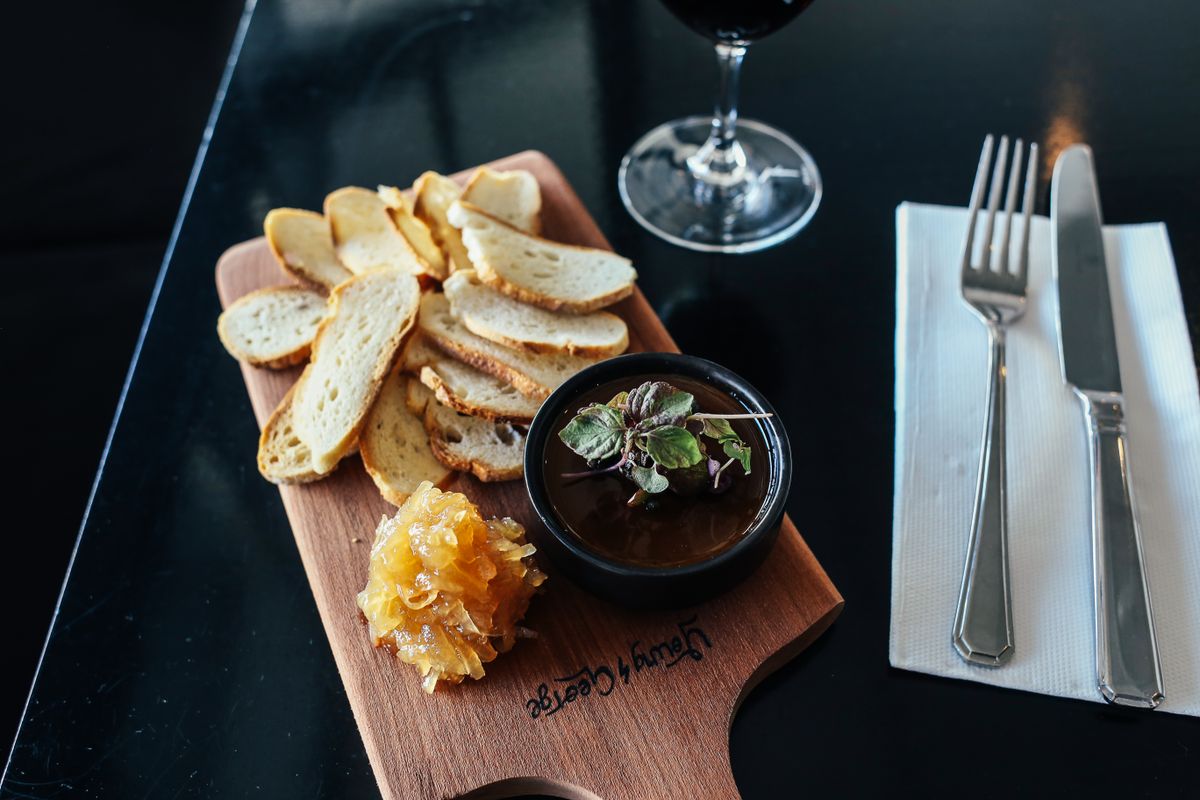 A dark tasting board of pâté, honeycomb and red wine