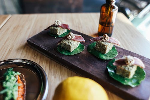 Close up of Snacks with Flower Leaves on a Wooden Board