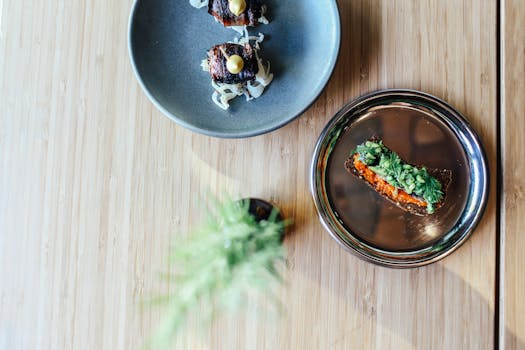 Elegant plating of gourmet dishes on wooden table, showcasing fine dining artistry.