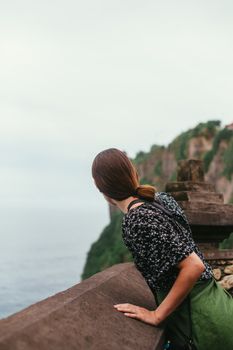 一名女子在风景优美的悬崖边眺望大海，捕捉户外宁静的时刻