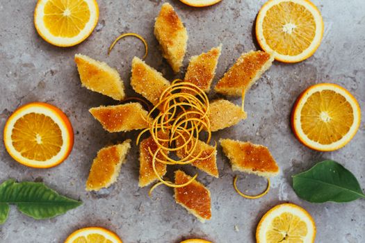 Delicious homemade citrus dessert garnished with fresh orange slices and zest in an overhead shot.
