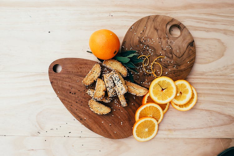 Orange Slices And Biscotti On Wooden Chopping Boards