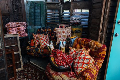 Free A vintage-style living room featuring vibrant patterned armchairs and pillows in a rustic setting. Stock Photo