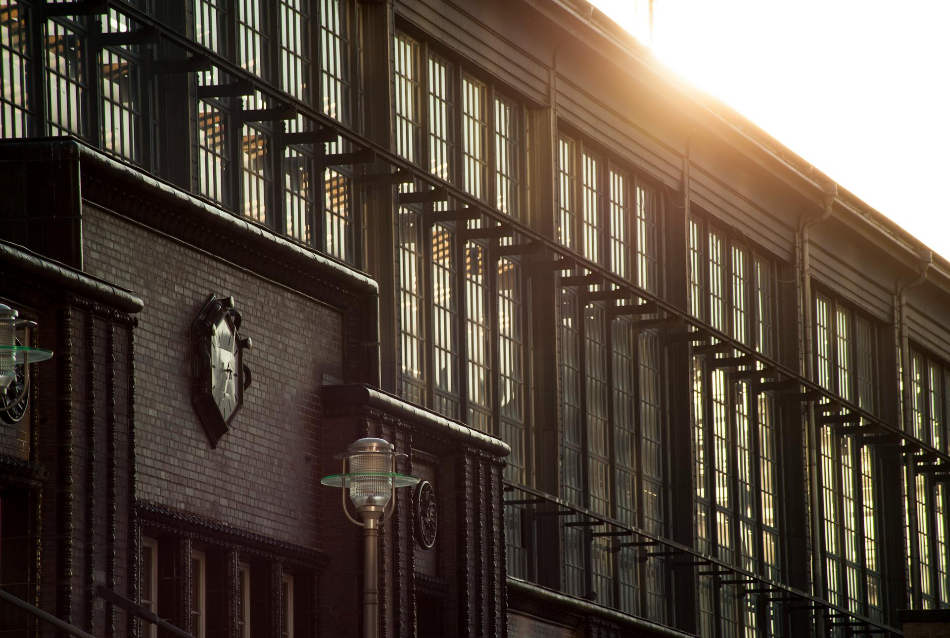 Dramatic view of historic brick facade with sunlight through windows capturing architectural details.