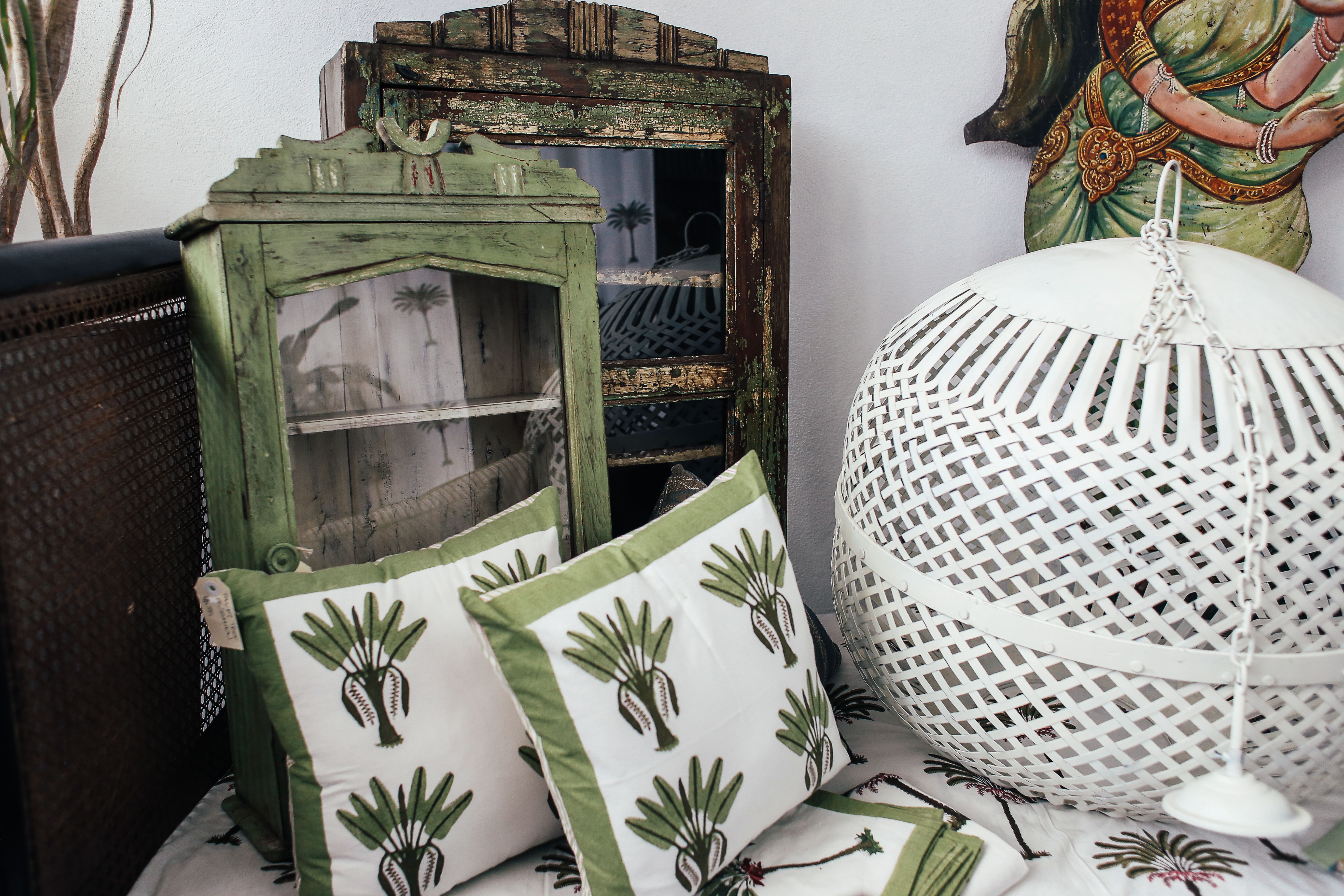 Artistic vintage decor arrangement featuring cushions and wooden furniture.
