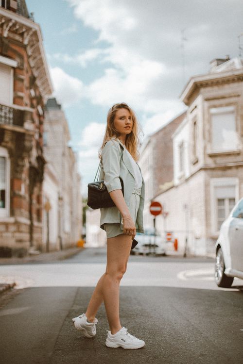 Free A stylish woman in casual outfit walking through a historic city street. Stock Photo