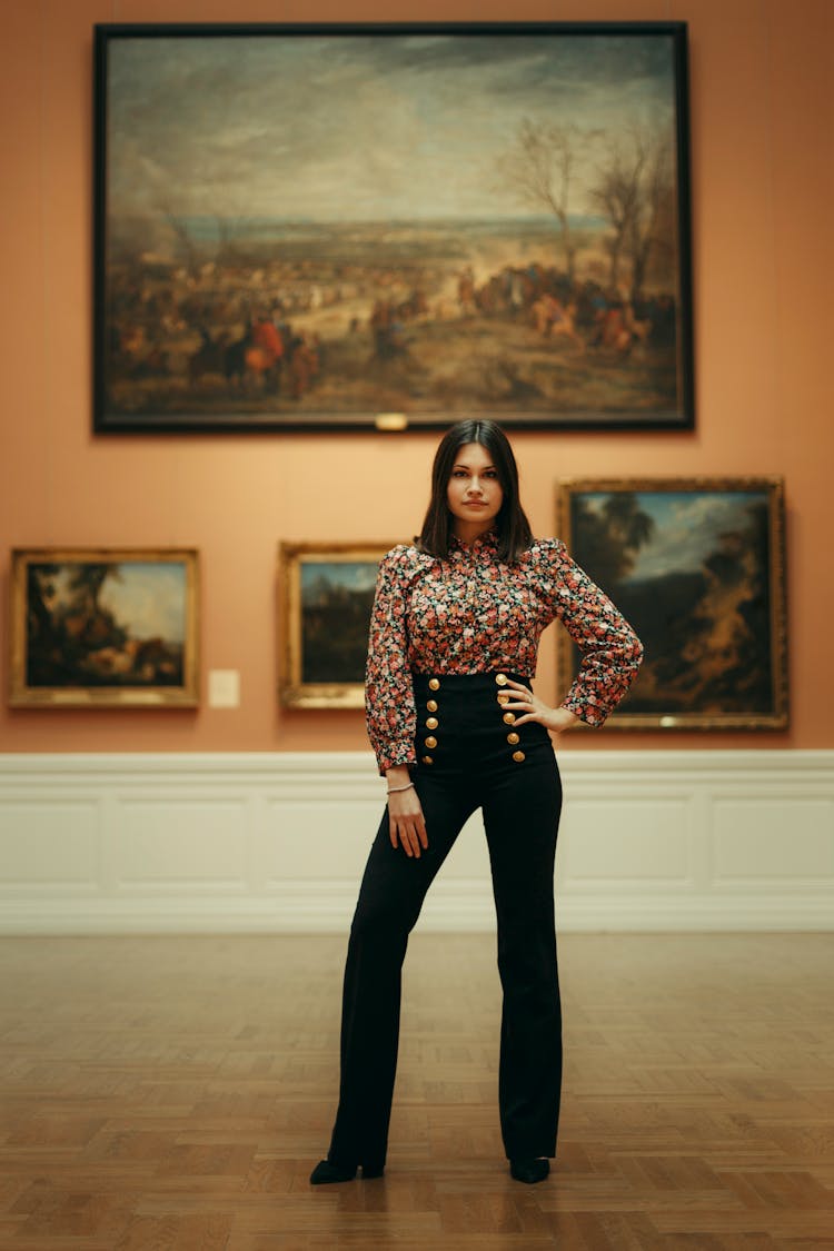 A Woman In Black Pants Standing Near Painting