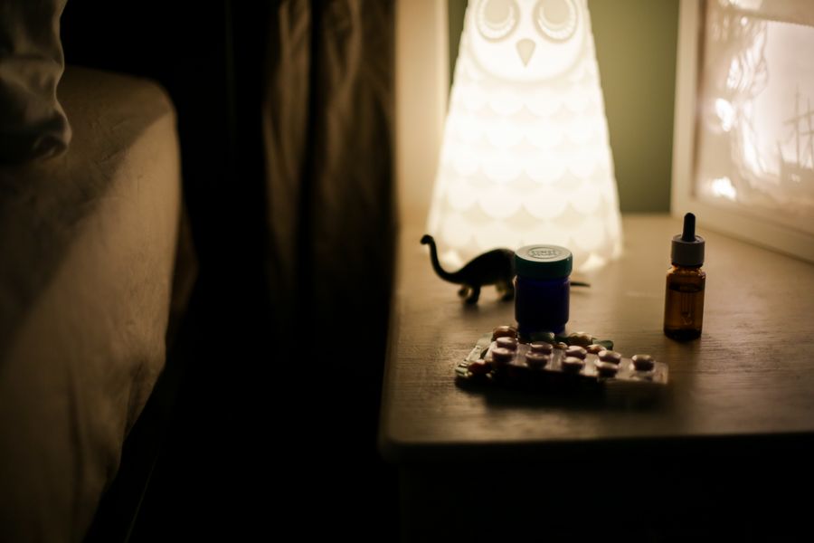 A cozy bedside table at night with a soft lamp and a supplement bottle — an evening magnesium routine.