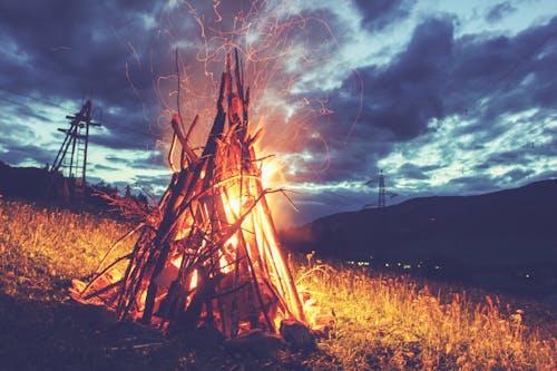 Burning bonfire with sparks in darkness