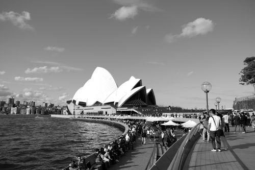 Free Black and white photograph of the iconic Sydney Opera House with bustling harbor area. Stock Photo