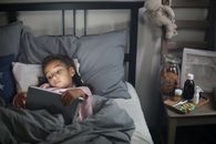 Boy in Gray Sweater Lying on Black Couch