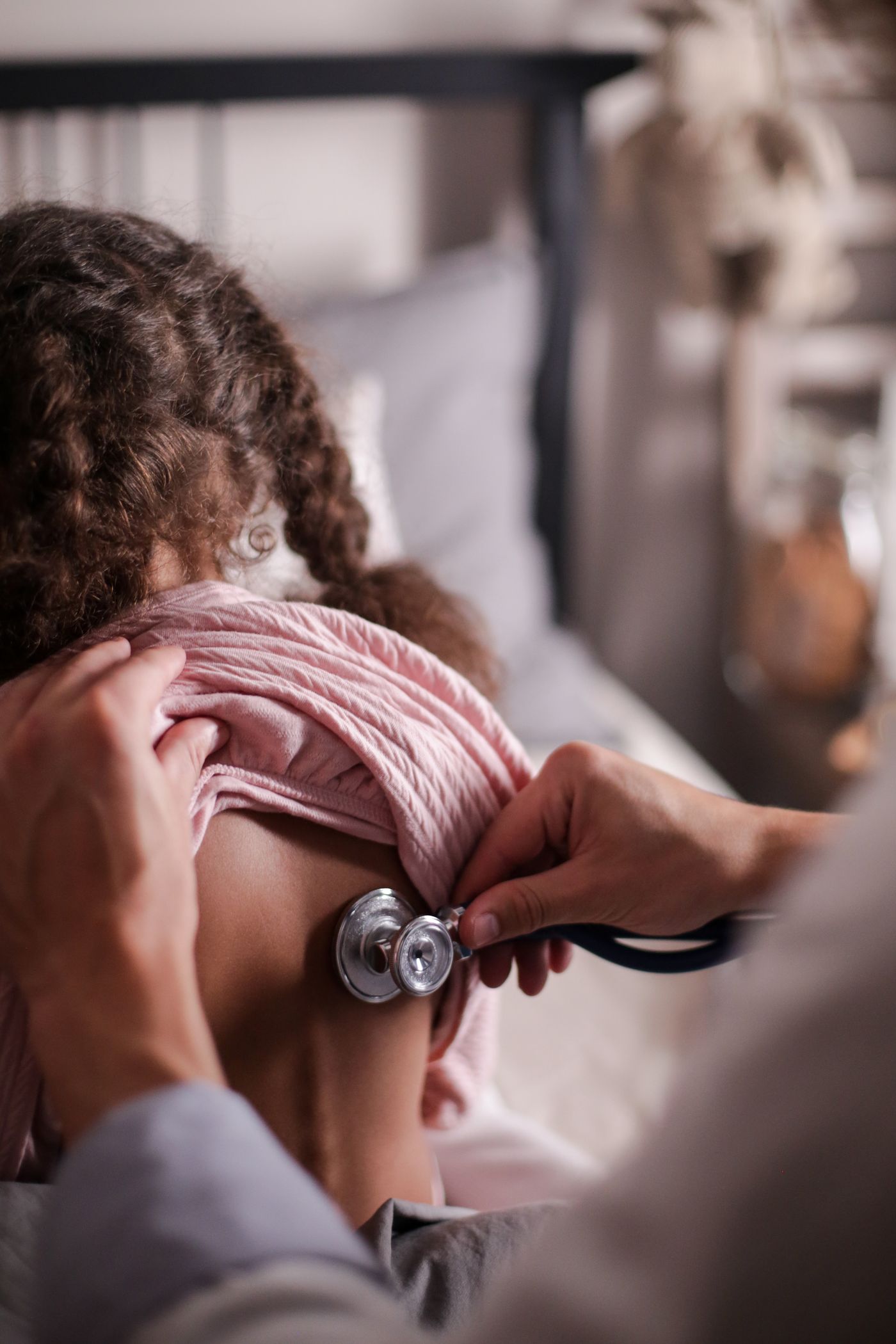 A pediatrician gently consulting a young child in a warm, calm clinic setting