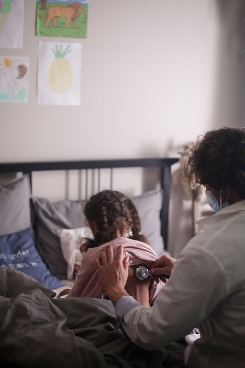 Pediatra examina criança com estetoscópio em ambiente doméstico tranquilo